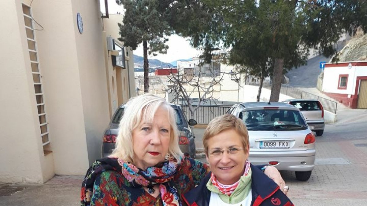La alcaldesa le entrega a la enfermera jubilada un ramo de flores de parte de todos los vecinos.