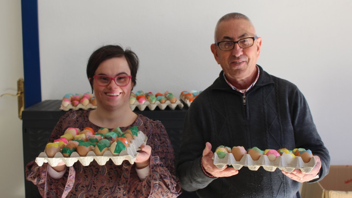 Dos de los usuarios de Asprodalba muestran algunos de los huevos que han elaborado.