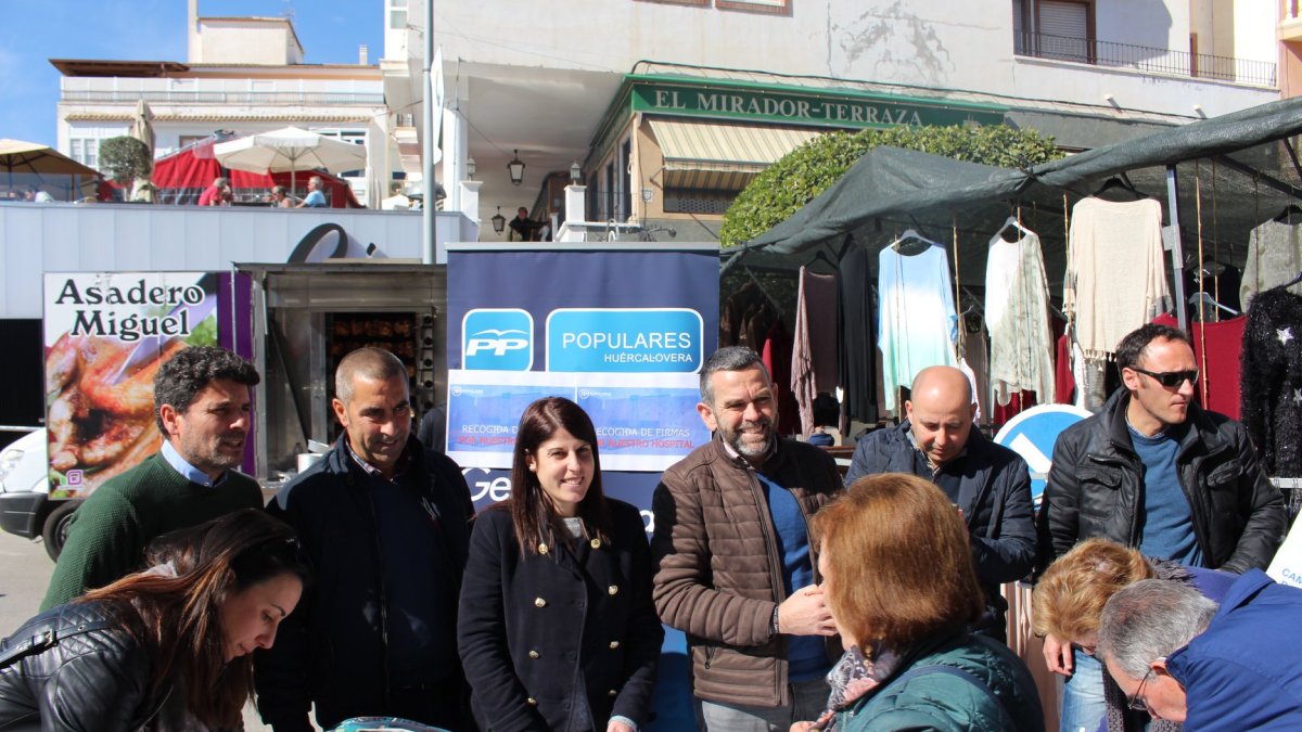 Un ciudadano firma la petición frente a los dirigentes del PP huercalense.