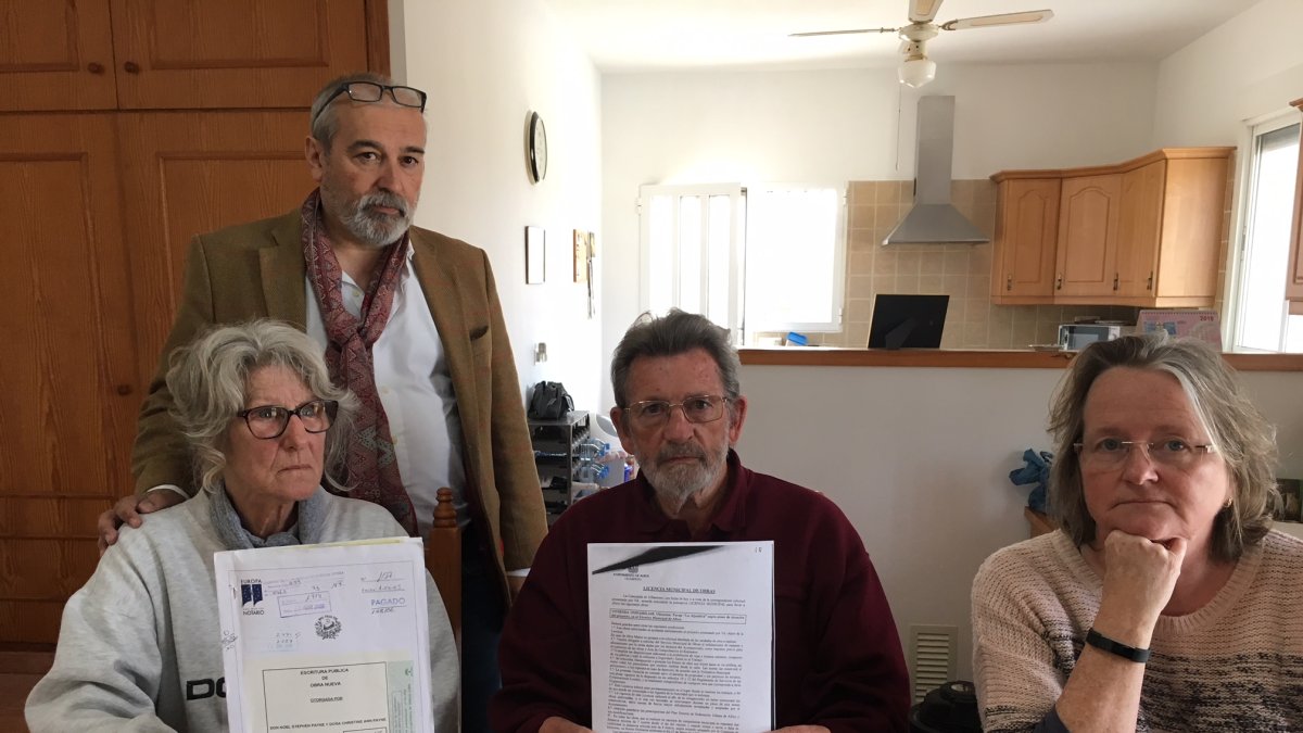 Los Payne sentados a la izquierda, mostrando la licencia de obras y la escritura.