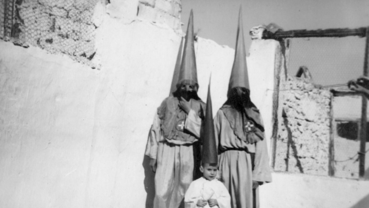 Penitentes de la cofradía de Banca y Bolsa en un terrado de la calle del Calvario.