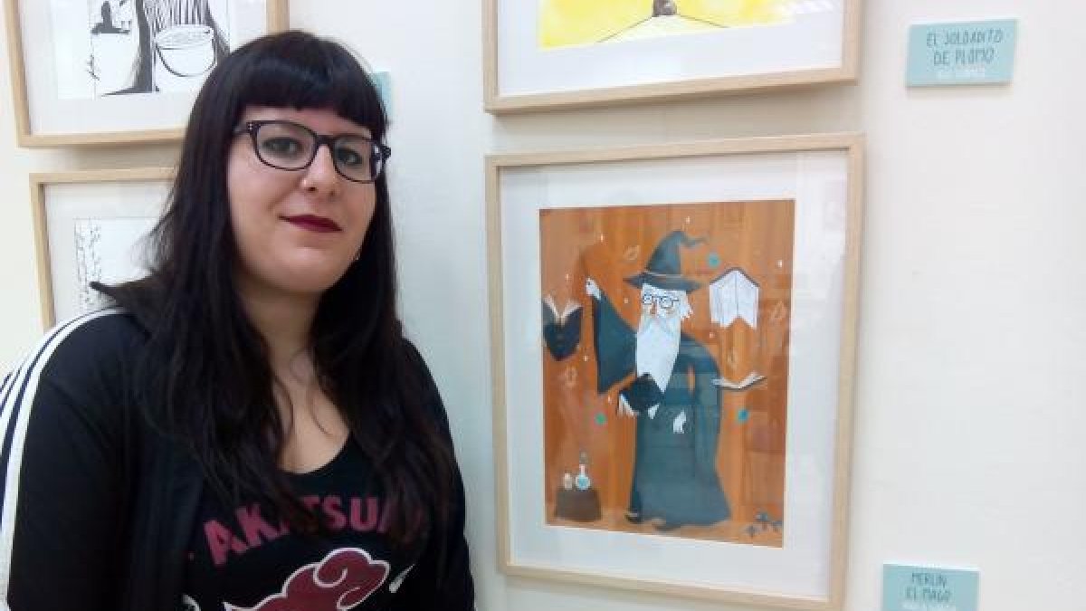 La ilustradora Paula García, junto a una de sus obras.