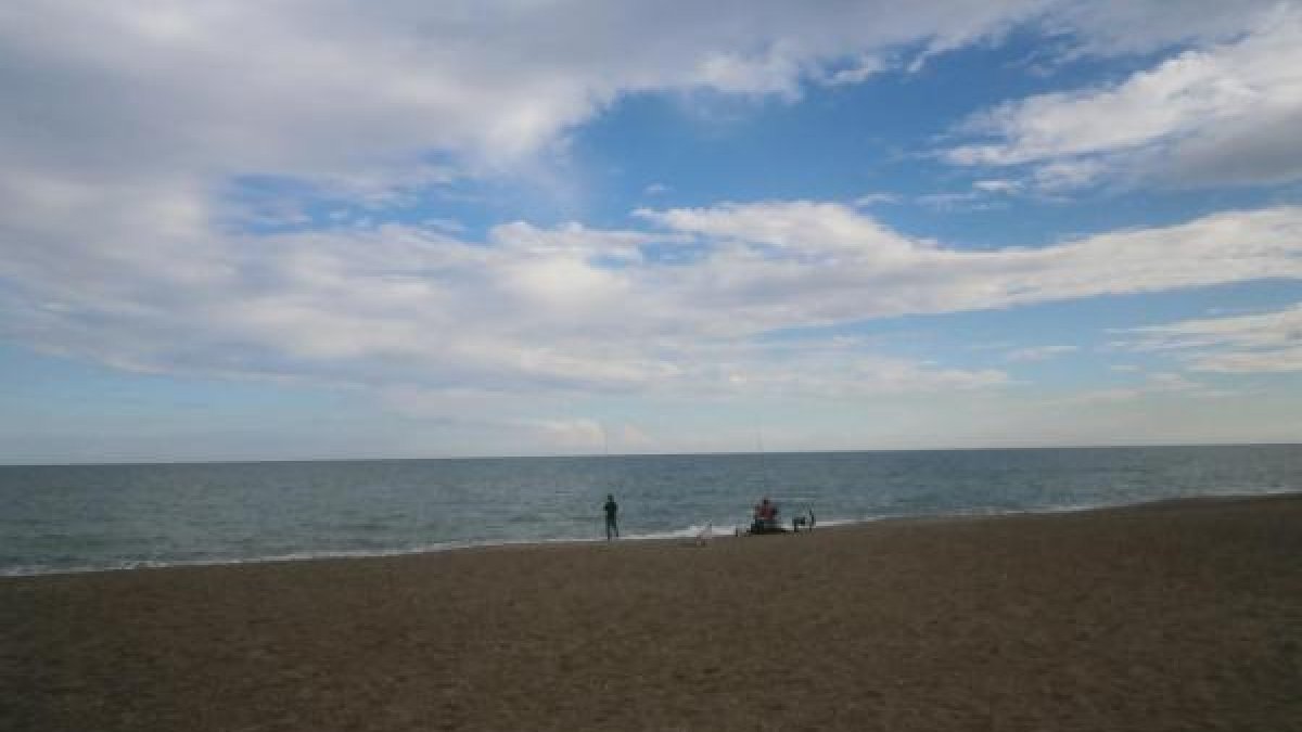 Hombres pescando en la playa de Palomares.