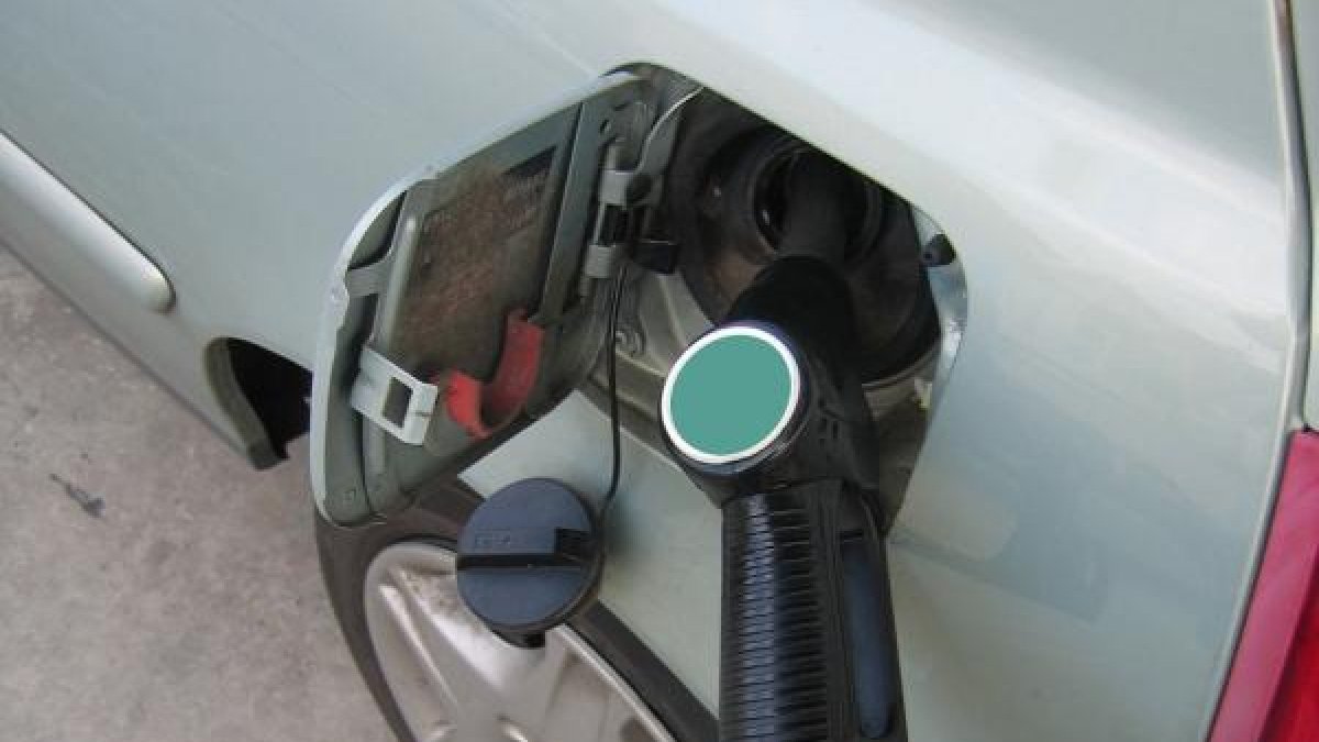 Un conductor echa combustible a su vehículo.