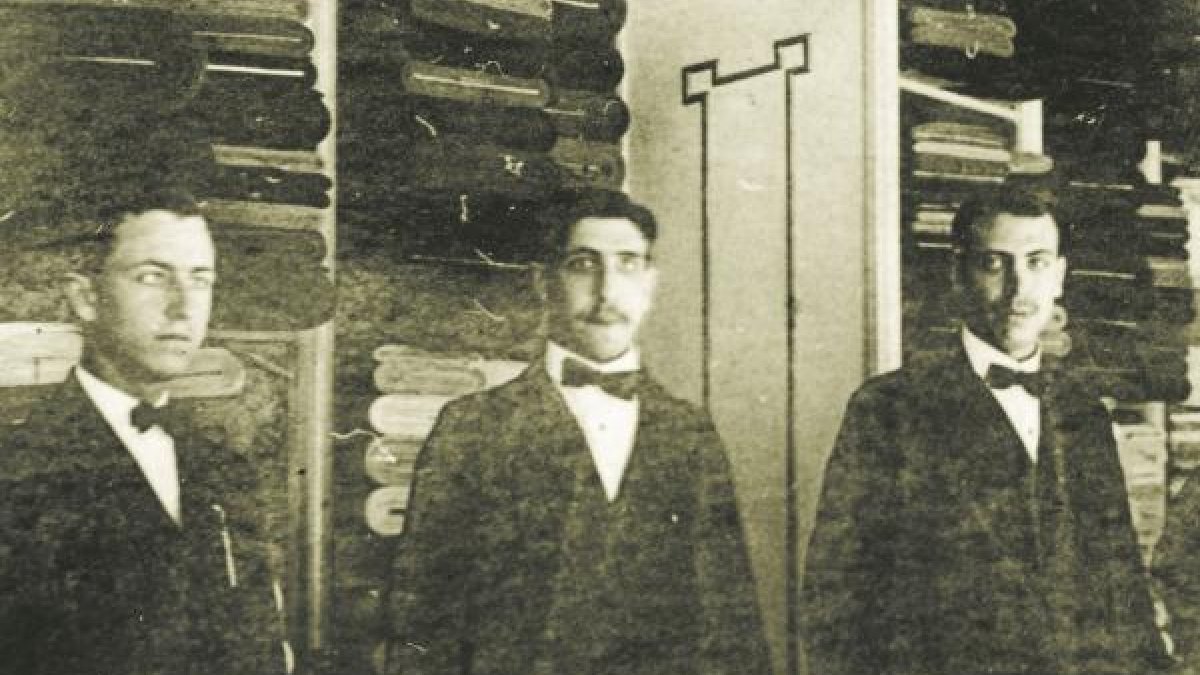 Empleados de La Pajarita en sus primeros años, donde se ven los estantes de tejidos.