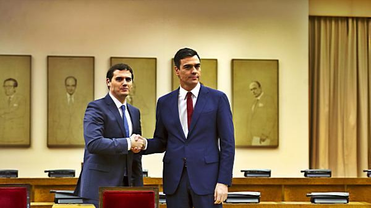 Apretón de manos tras la firma del pacto.