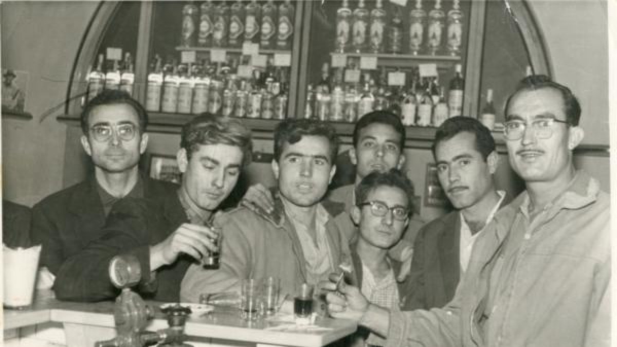 Balta con sus gafas de cristales redondos, en una de las esquinas de Casa Puga compartiendo unos chatos de vino con los comerciantes y empleados de l