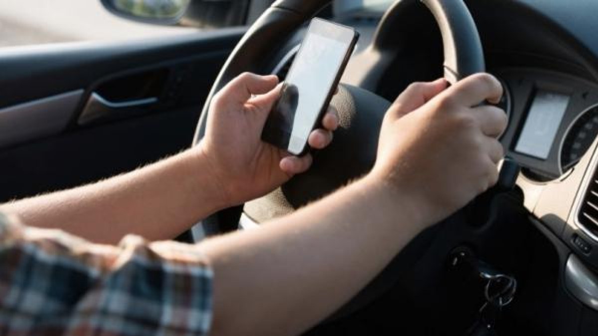 Un conductor usa el móvil mientras conduce.