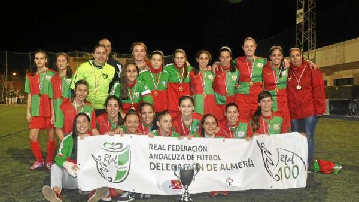 Las jugadoras arlequinadas con la pancarta del Centenario de la Andaluza.