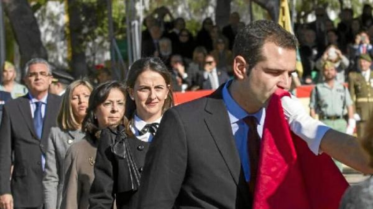 El alcalde besa la bandera.