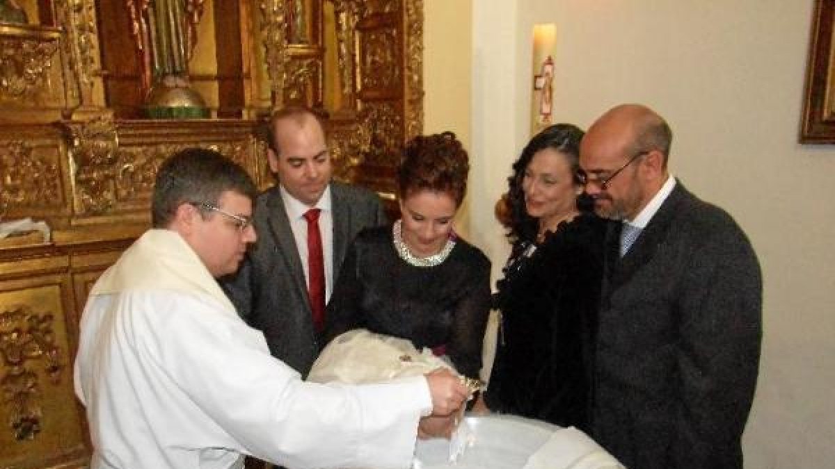 El sacerdote Francisco González en el momento del bautizo de la pequeña Martina, estando con sus padres y padrinos.