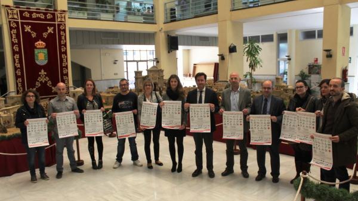 Comerciantes locales junto a varios miembros del Ayuntamiento con el cartel de presentación de la recogida.