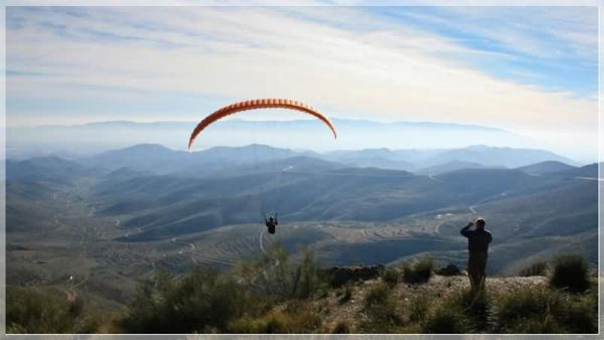 Un parapentista sobrevuela la zona de Collado García, en Tahal.