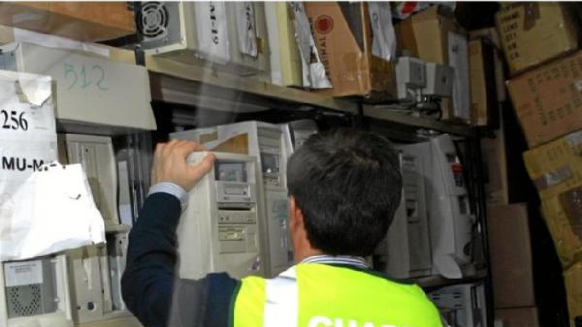 Un agente revisa equipos informáticos.