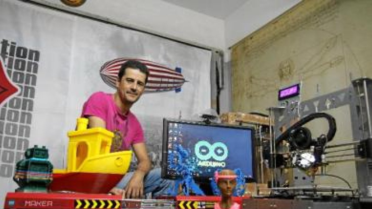 Miguel Ángel en el taller de su casa en Huércál, repleto de máquinas impresoras y objetos creados con ellas.