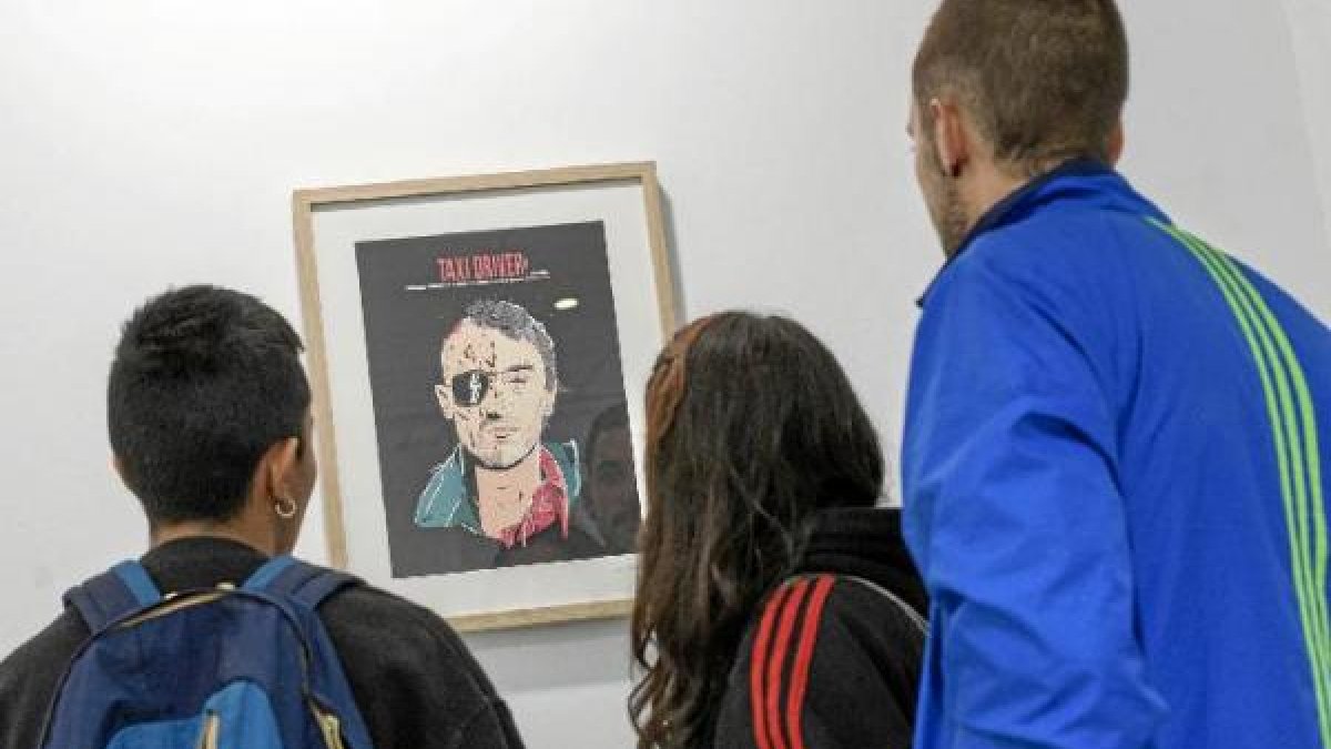 Visitantes a la muestra ‘Personajes’ viendo el retrato de De Niro en ‘Taxi Driver’.