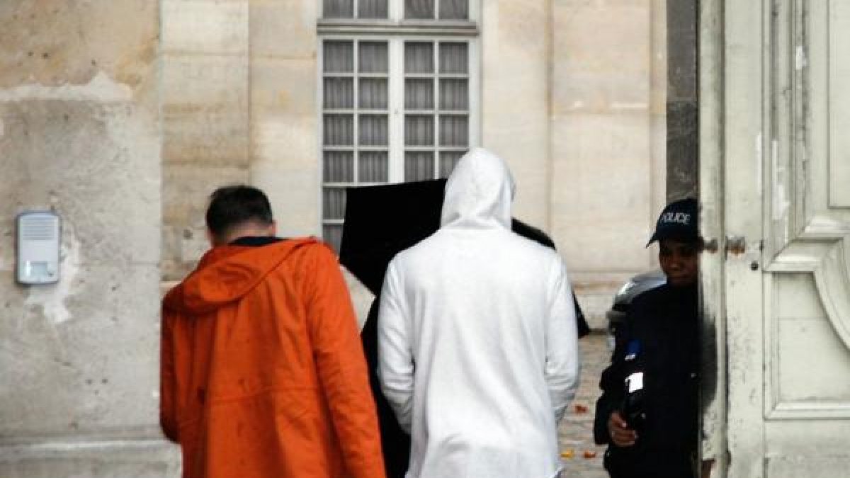 Benzema, de blanco, a su llegada a la comisaría de Versalles, en París.