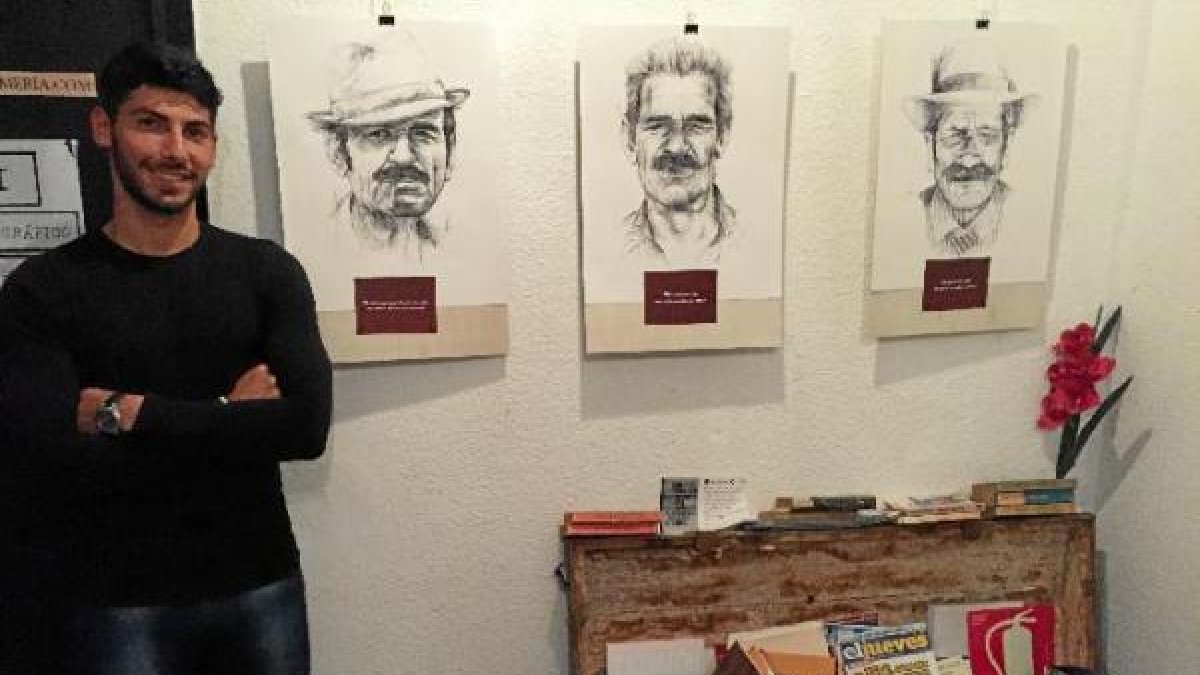 Juan Andrés Amaya posa junto a tres de los diez dibujos que forman su primera exposición.