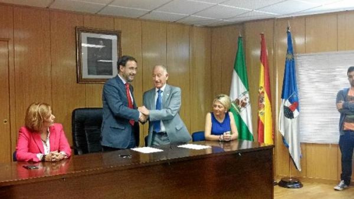 Apretón de manos tras la firma del convenio.