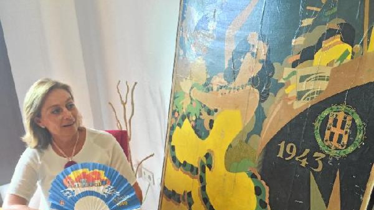 Aurora Carretero, la directora de la sección de Archivos y Bibliotecas del Ayuntamiento, con un abanico del 99 y un cartel de Feria del 43.