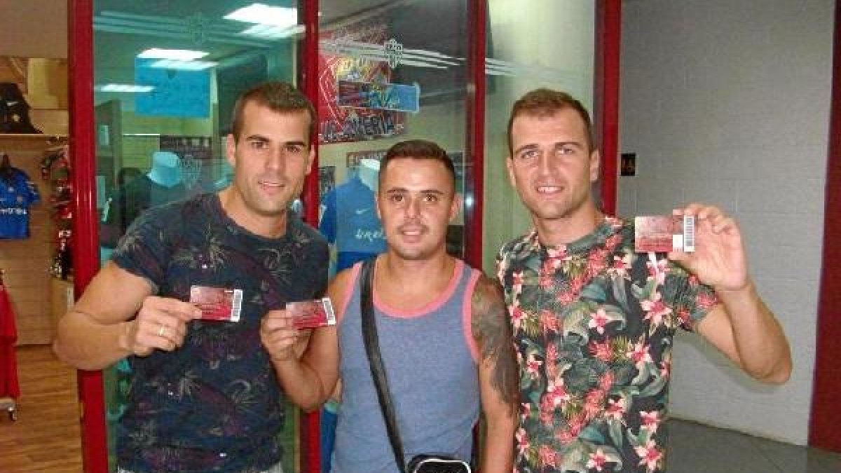 Los aficionados muestran con orgullo el abono rojiblanco.