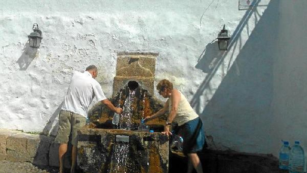 Vecinos de La Curva cogiendo agua de la Fuente del Alméz para beber en casa.