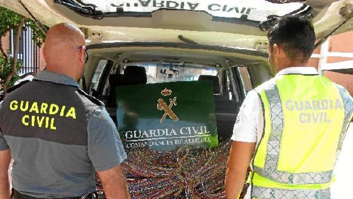 Agentes observan el material localizado al detenido.