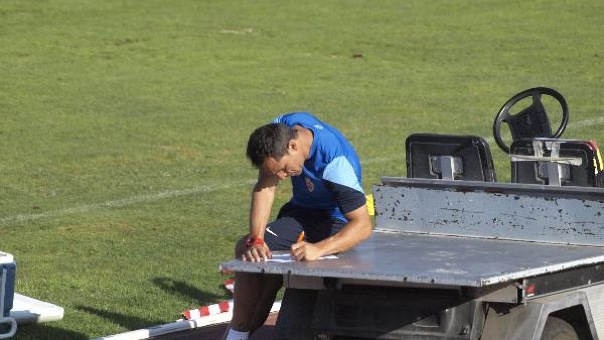 El míster, tomando nota en el coche del material.
