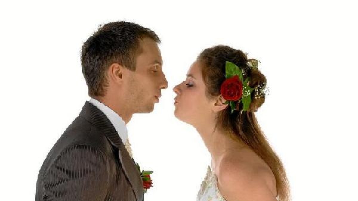 Dos jóvenes posan vestidos de novios.