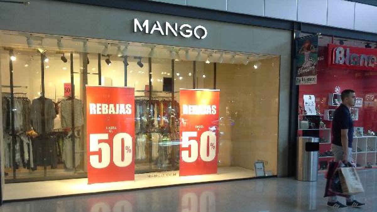 Carteles anunciadores de rebajas en un centro comercial.