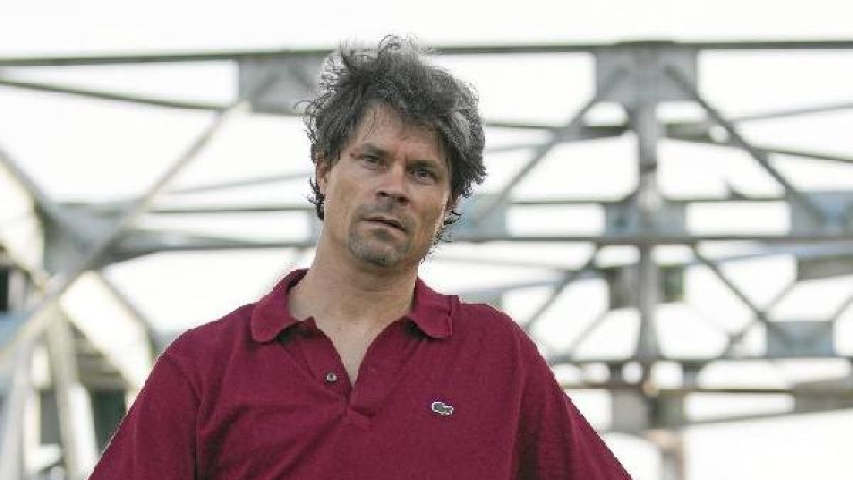 John Julius Reel posa con el libro en el puente de Alfonso XIII de Sevilla.