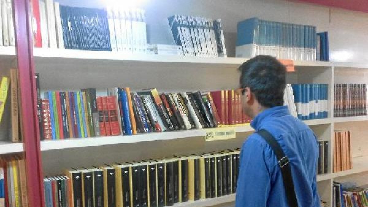 Un joven consulta los libros disponibles.