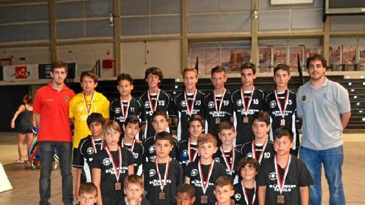 Los dos equipos posan con sus medallas.
