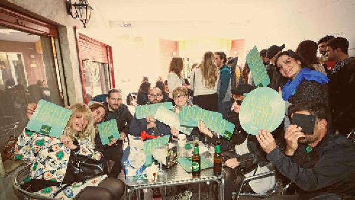 Los Clientes de la Cafetería Alhambra muestran carteles con la palabra Tardeo, una iniciativa de la asociación.