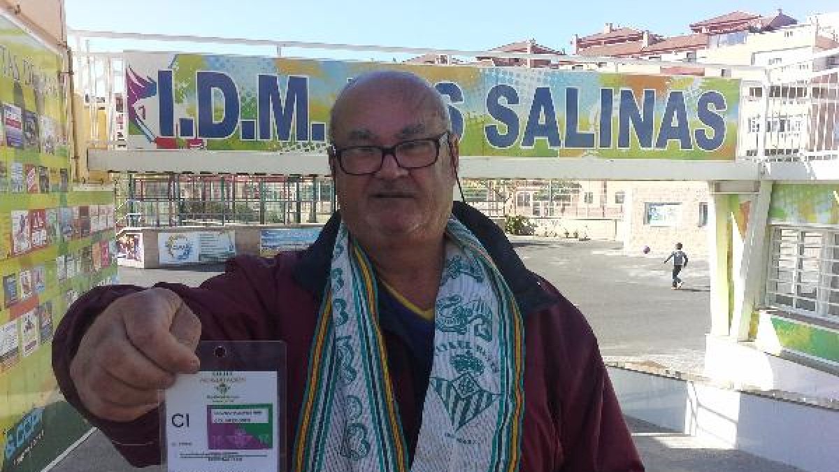 Con el carné del Betis y la bufanda verdiblanca.