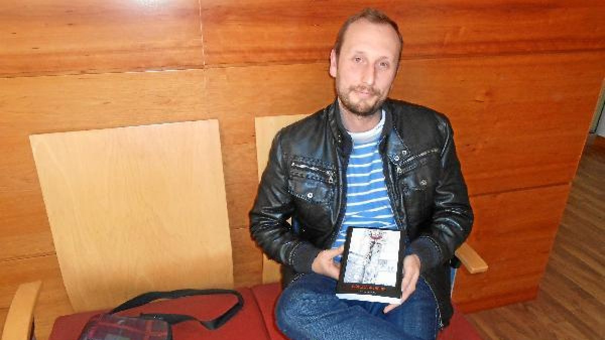 Muñoz Paredes muestra un ejemplar de la obra en la redacción de LA VOZ y la SER.