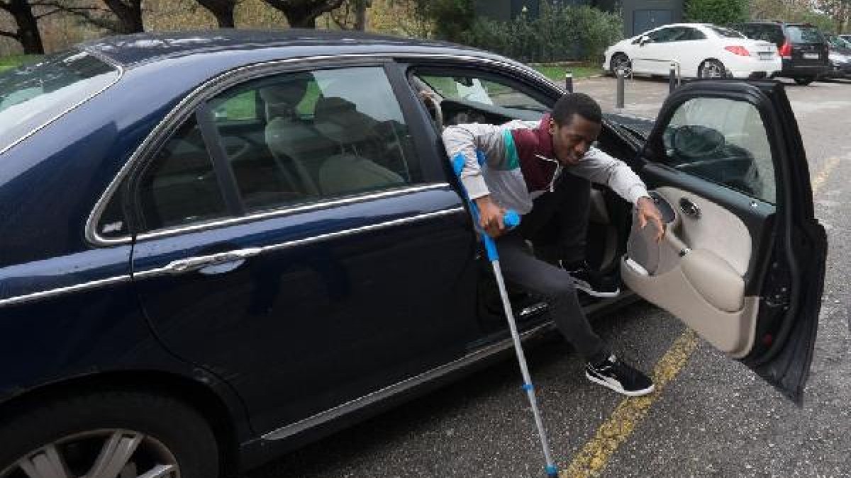 Koné, bajándose del coche con muletas.