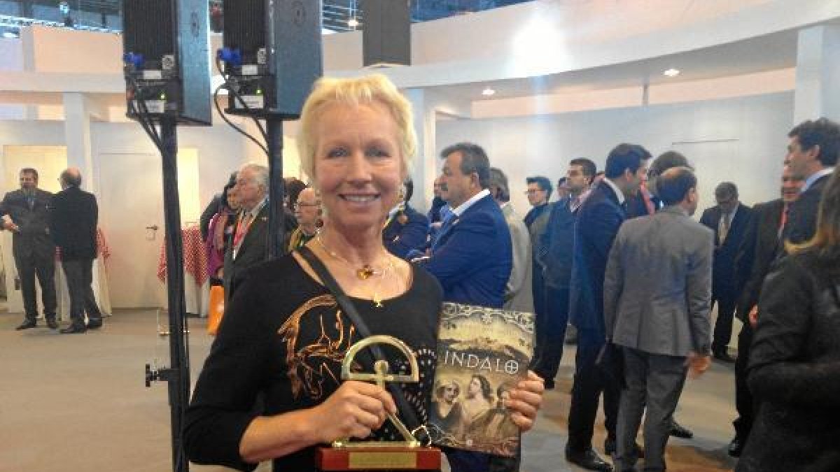 La escritora con su libro y el Indalo de Oro en la última edición de Fitur.