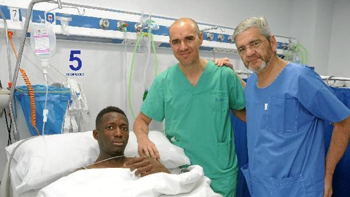 El jugador del Granada con los doctores tras la operación.