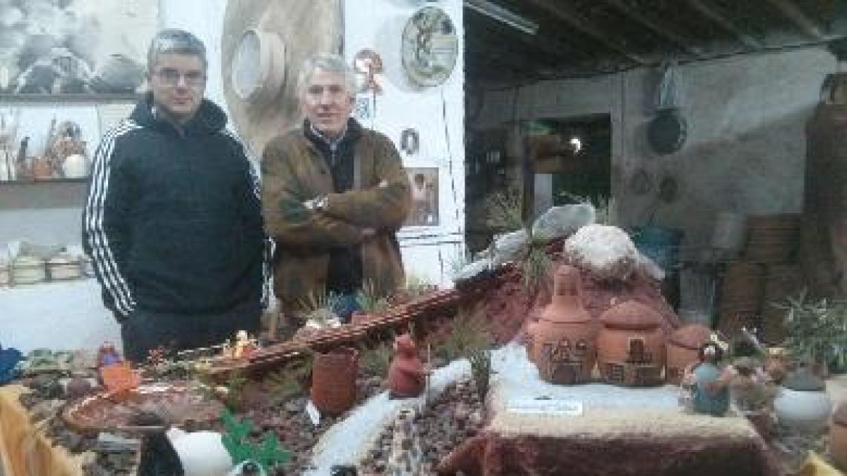 Antonio y Juan Alfonso posan junto al belén que han creado utilizando utensilios tradicionales