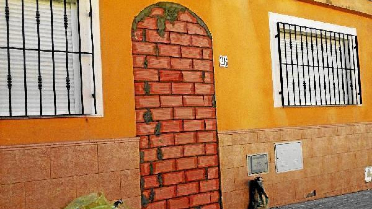 Puerta de una de las casas tapiada tras el desalojo