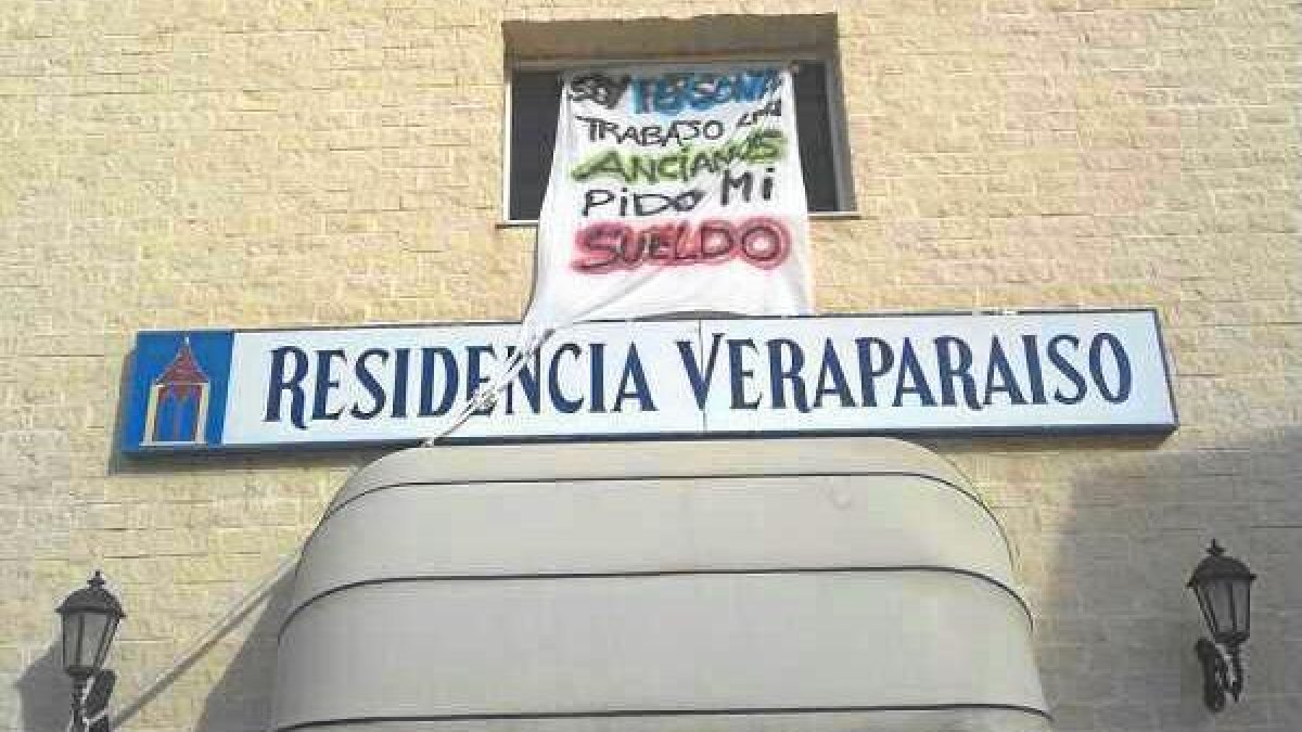 Fachada de la residencia con carteles de protesta.