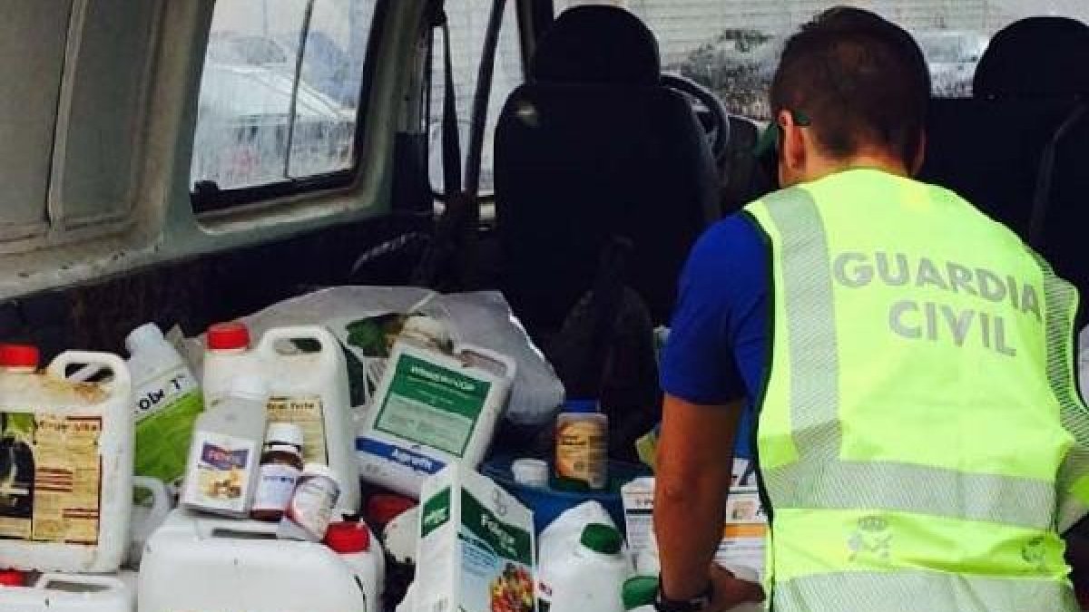 Un guardia civil junto a fitosanitarios y productos robados en una explotación