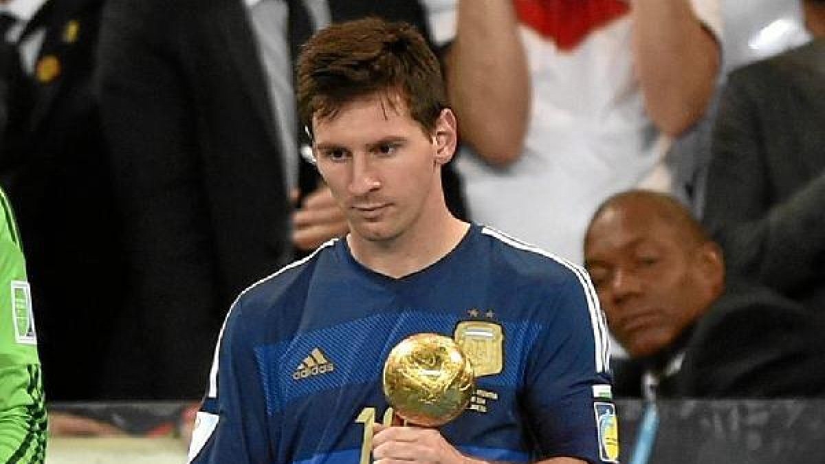 Leo Messi triste por la derrota ante Alemania con su trofeo.