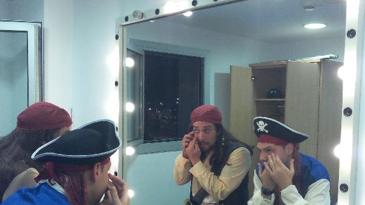Dos de los personajes se maquillan antes de salir a escena.