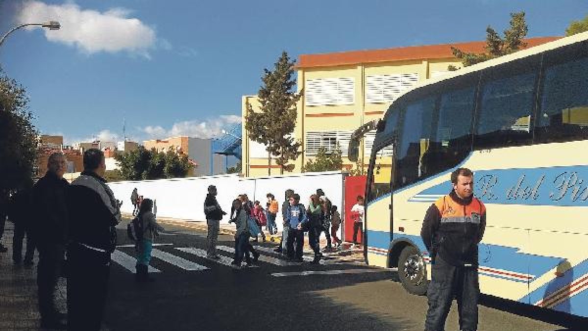 Un voluntario de Protección Civil ayuda a los niños a salir con seguridad en Las Lomas.