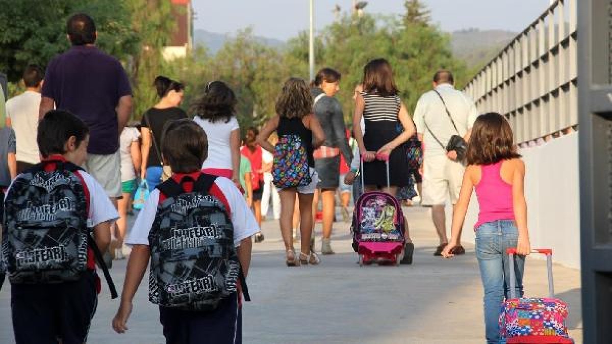 Niños en edad escolar en el acceso a su centro educativo.