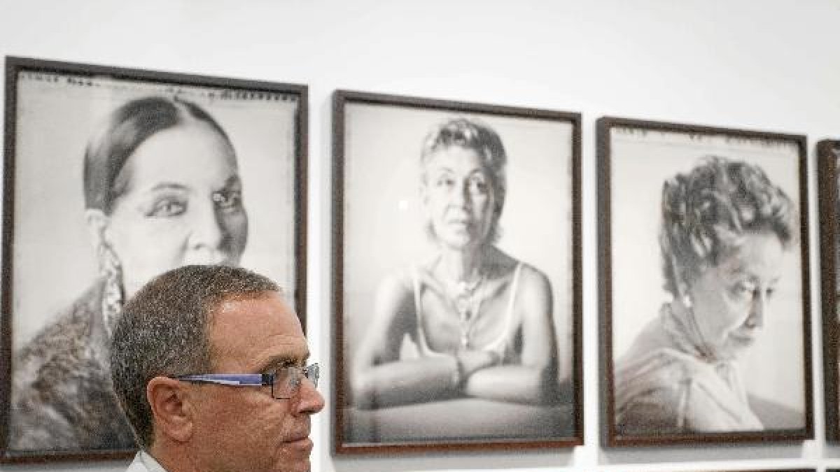 Chema Conesa, frente a algunos de los retratos que muestra en Almería.