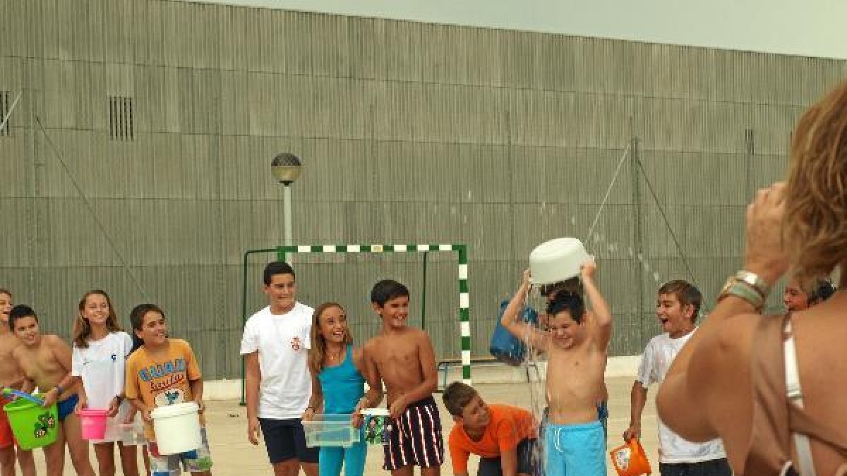 Momento en el que uno de los alumnos, ante la mirada de los otros, se arroja el cubo del agua helada