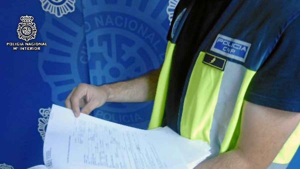 agentes de la Policía Nacional muestra documentación aprehendida